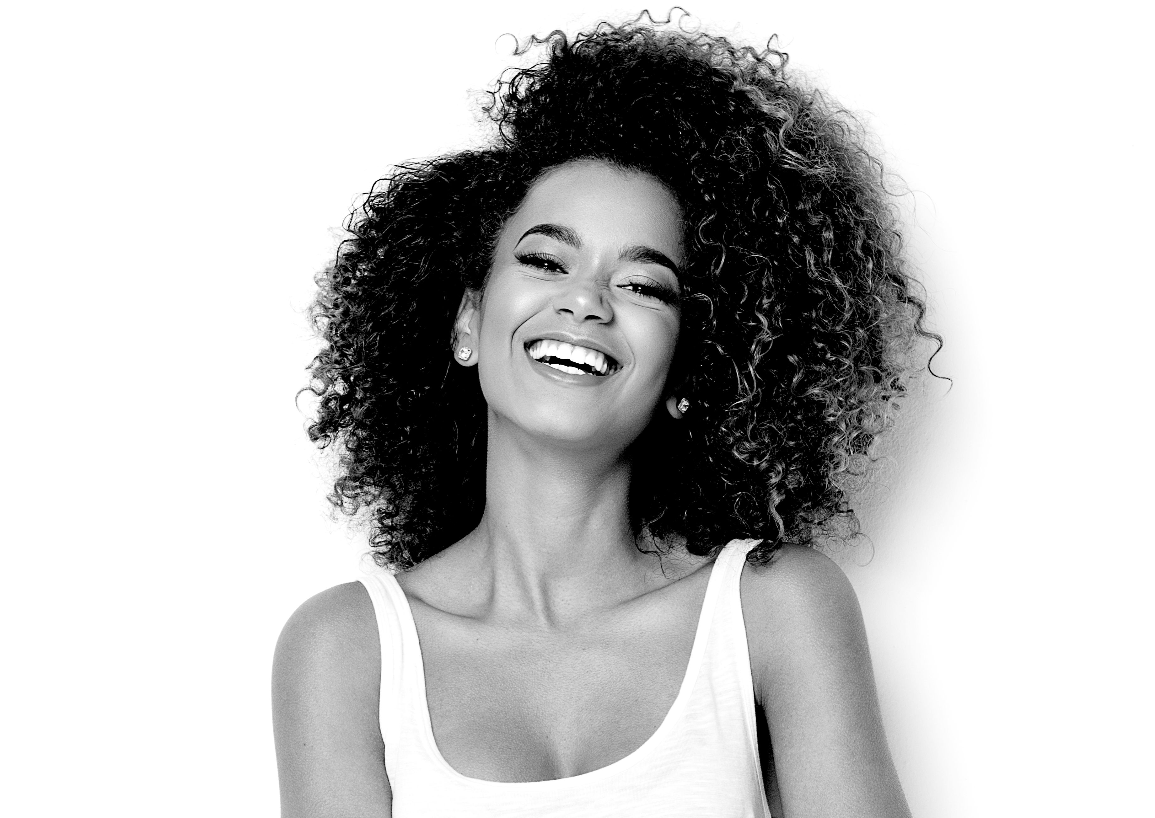 A smiling picture of the young lady with curly hair